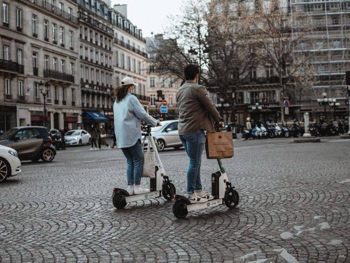 two people riding electric scooters
